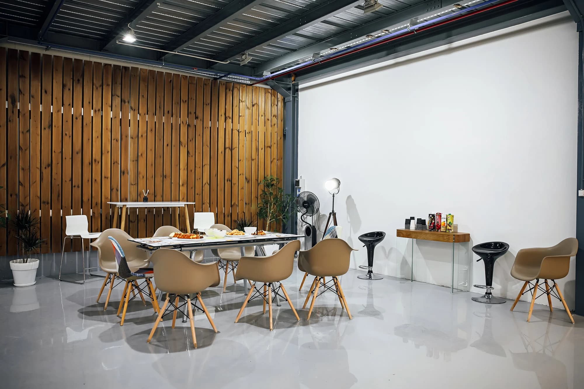 Reception area inside the facility, with a slatted timber wall, a long table and seating.