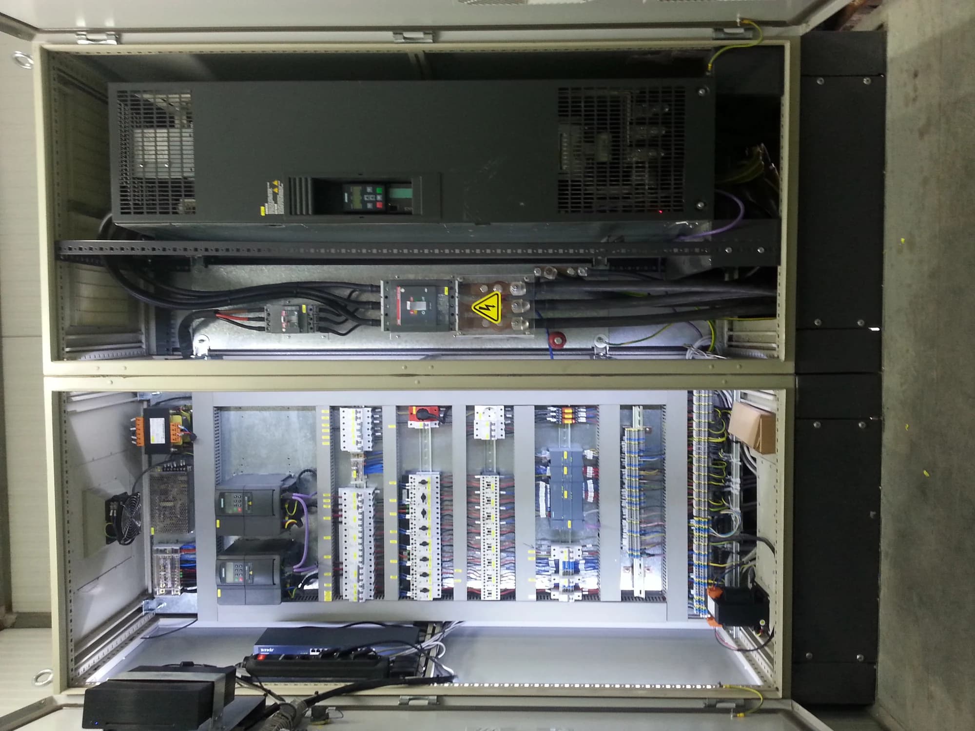 Internal control section of a cabinet with modular equipment mounted on rails.