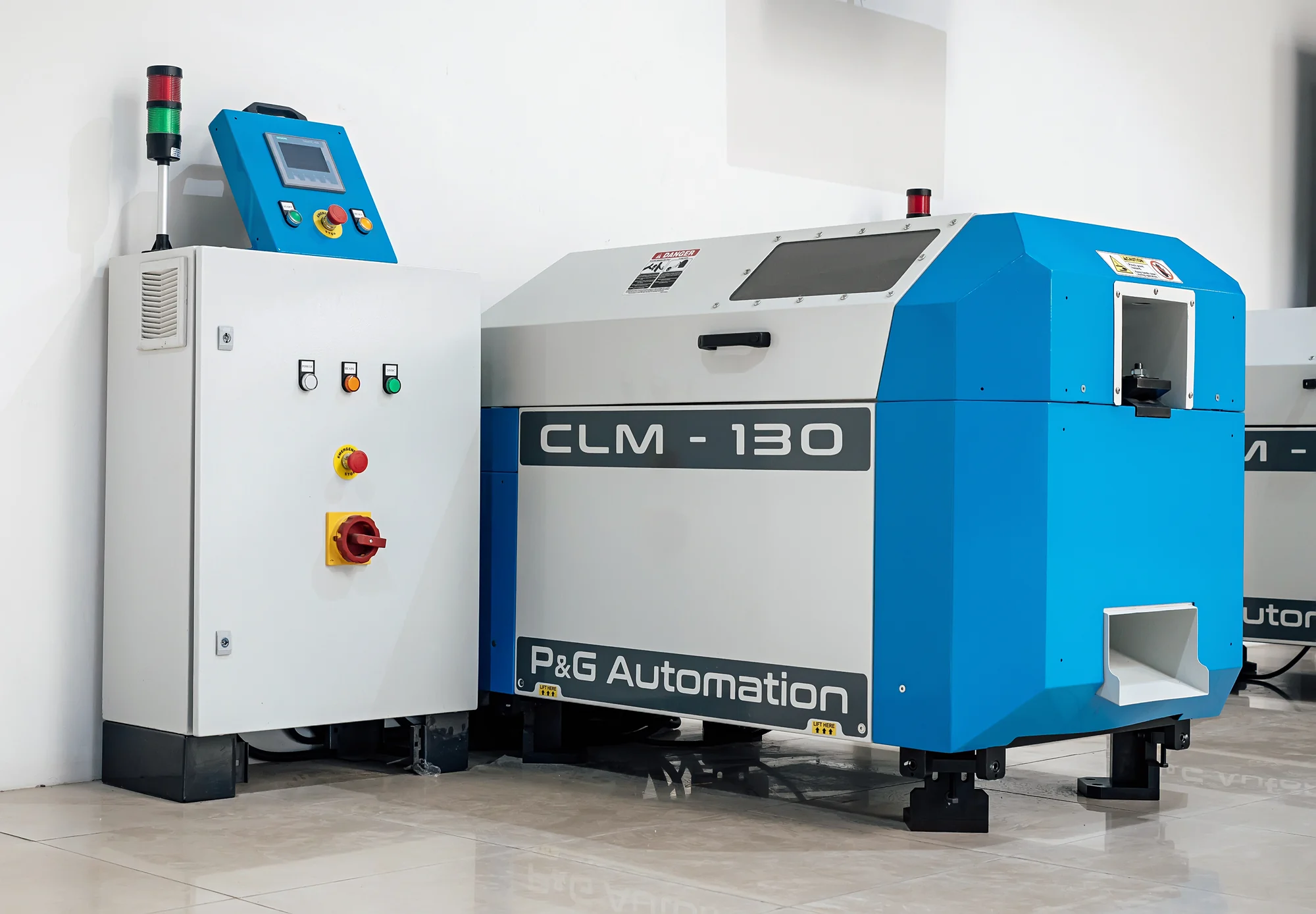 The chamfering machine beside its separate control cabinet with signal tower.