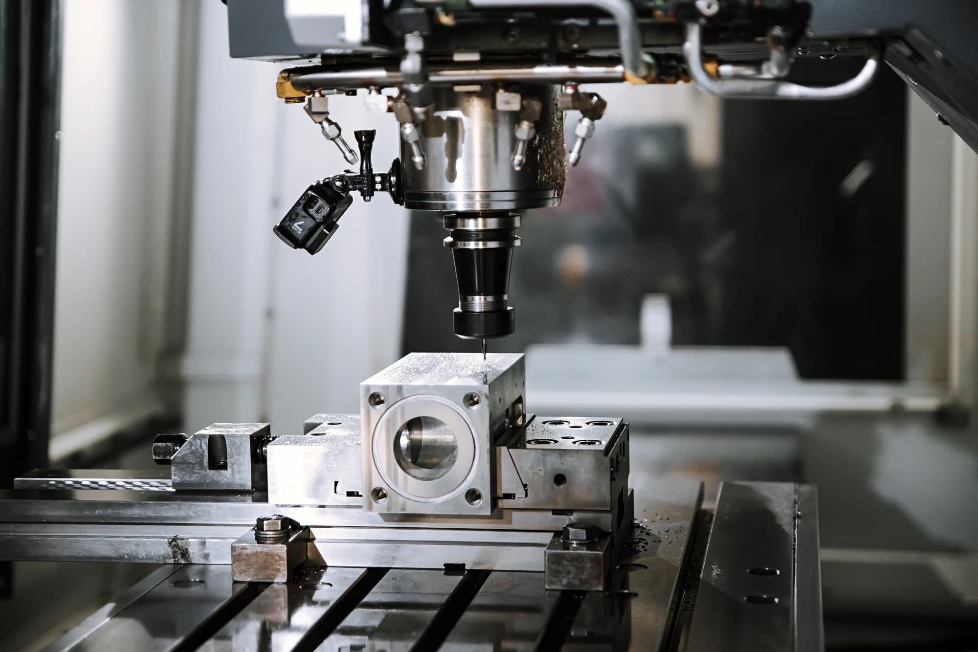 Machining head cutting a component held in a fixture on the machine table.